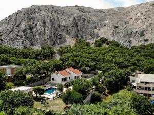 una vista aérea de una casa frente a una montaña en Villa Pag Dubrava Relax with Pool, en Pag