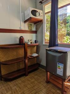 a small kitchen with a stove and a microwave at Noho Mai in Nuku Hiva