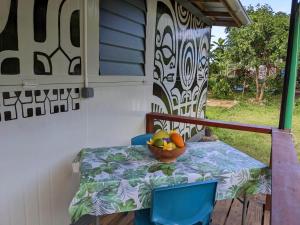 a table with a bowl of fruit on a porch at Noho Mai in Nuku Hiva