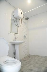 a white bathroom with a toilet and a sink at Doris Seminyak Studio in Seminyak +16 photos