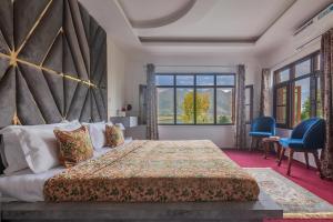 - une chambre avec un grand lit et une grande fenêtre dans l'établissement StayVista at Buhayra Lakefront, à Srinagar