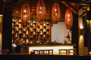 a man standing behind a bar in a restaurant at Japamala Resort by Samadhi - Adults Only in Tioman Island
