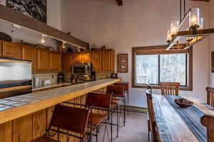 a kitchen with a bar with chairs and a table at Bridgepoint Condo 24 - On Trail Creek & Walk to Downtown and Bald Mt in Ketchum