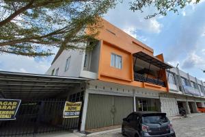 a car parked in front of a building at OYO 92928 Lavina Guesthouse in Dumai