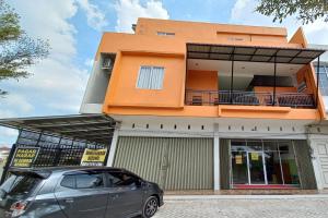 a car parked in front of a building at OYO 92928 Lavina Guesthouse in Dumai