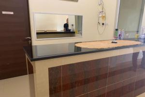 a bathroom with a counter with a mirror at OYO 92928 Lavina Guesthouse in Dumai
