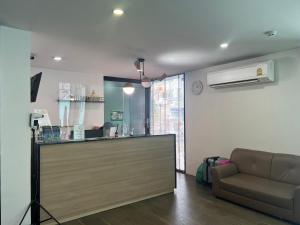 24Residence Siriraj في بانكوك: غرفة معيشة مع أريكة ومكتب