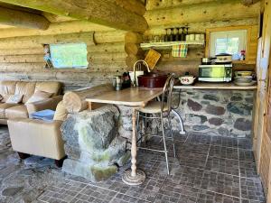 a kitchen with a table and a couch in a cabin at Suurekivi külalistemaja in Reigi