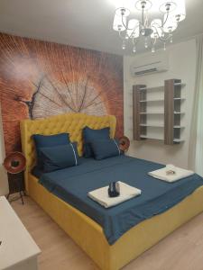 um quarto com uma grande cama amarela com almofadas azuis em Sandanski Apartments Top Center em Sandanski