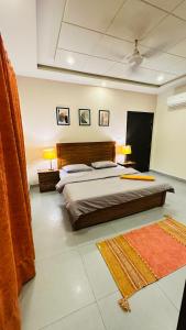 1 dormitorio con 1 cama, 2 lámparas y 1 alfombra en House Of Wabi Sabi, en Rawalpindi