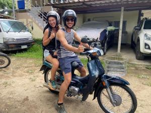 a man and a woman sitting on a motorcycle at JJ&J Garden in Pai