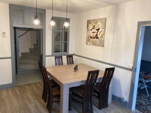 a dining room with a wooden table and chairs at LA FINNOISE in Fains-les-Sources