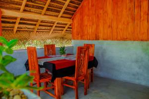 einen Tisch und Stühle in einem Zimmer mit Dach in der Unterkunft Sigiri Enaya Cottage in Sigiriya