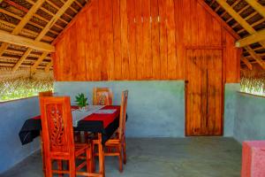 ein Esszimmer mit einem Tisch und Stühlen in einer Scheune in der Unterkunft Sigiri Enaya Cottage in Sigiriya
