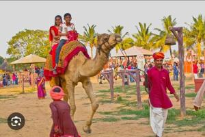 a group of people riding on the back of a camel at Swad Ri Dhani, Ajmer in Ajmer