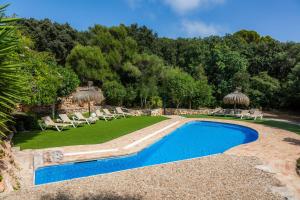 a swimming pool with lounge chairs and a yard at Finca Son Favar Capdepera in Capdepera