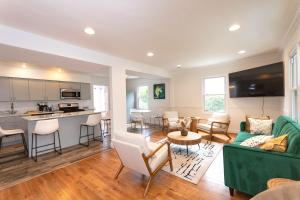 a living room with a green couch and a kitchen at Takoma Park Home ~ 6 Mi to the National Mall! in Takoma Park