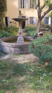 einen Brunnen vor einem Gebäude mit einem Baum in der Unterkunft Nevina centro camera privata in appartamento in Parma