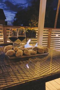 a tray of bread and two glasses of wine on a table at MaxiMar Apartment With Sauna in Valga