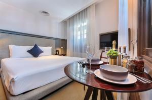シンガポールにあるAnn Siang House, The Unlimited Collection managed by The Ascott Limitedのベッドルーム1室(ベッド1台、テーブル、プレート付)