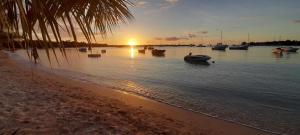 a beach with boats in the water at sunset at Coco Lux Mon Amour in Grand Baie