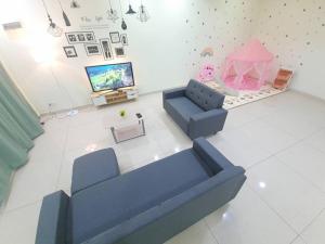 un salon avec un canapé bleu et une tente rose dans l'établissement 6243 Sbn Jaya # U Homestay, à Seremban