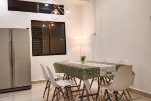 une salle à manger avec une table et des chaises vertes dans l'établissement 6243 Sbn Jaya # U Homestay, à Seremban