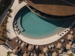 una vista aérea de una piscina con sillas y agua en Pnoe Breathing Life - Adults Only en Karteros