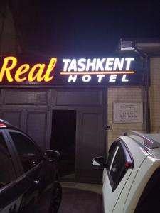 een echt restaurantbord aan de zijkant van een gebouw bij REAL TASHKENT Inn in Tasjkent