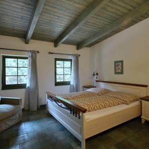 1 dormitorio con 1 cama, 1 sofá y 2 ventanas en Penzion U vinaře, en Velké Bílovice