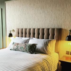a bed with a large headboard with a pillow on it at No.123 The Old Post House in Scalby