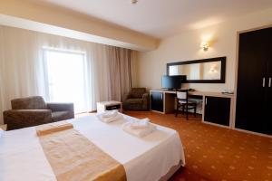 a hotel room with a bed and a desk at Hotel Oxford By TimHotels in Timişoara