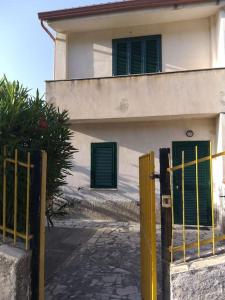 une maison avec deux portes vertes et un portail dans l'établissement Villetta a schiera con giardino e terrazza-S.Marco di C.te, à San Marco di Castellabate