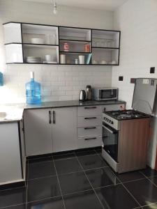 a kitchen with white cabinets and a stove top oven at Wellstaycation in Bungoma