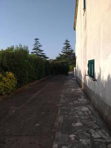 une rue vide à côté d'un bâtiment avec une fenêtre verte dans l'établissement Villetta a schiera con giardino e terrazza-S.Marco di C.te, à San Marco di Castellabate