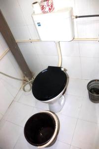 a bathroom with a toilet with a black seat at Stay Inn Heritage in Varanasi