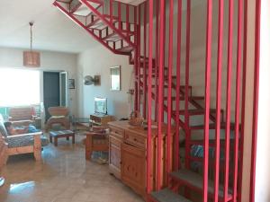un salon avec un escalier en colimaçon rouge dans l'établissement Villetta a schiera con giardino e terrazza-S.Marco di C.te, à San Marco di Castellabate