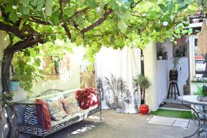 un sofá sentado bajo un árbol en un patio en Studio Cosy" La Cigale", en Fréjus