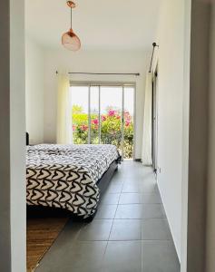 a bedroom with a bed and a window at Appartement Bahia Golf Beach in Bouznika