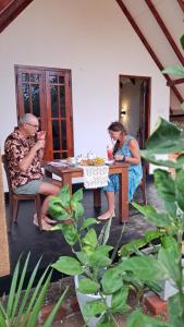 Un paio di persone sedute a un tavolo di Sigiri Enaya Cottage a Sigiriya Altre 37 foto