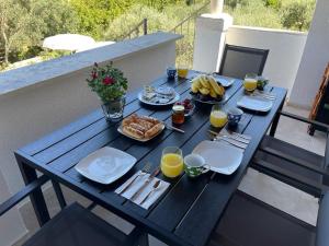 een picknicktafel met ontbijtproducten en drankjes op een balkon bij Vacation house Rubi in Dubrovnik