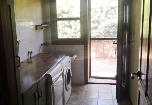 een keuken met een wasmachine en een raam bij La Casa Amarilla in Totana