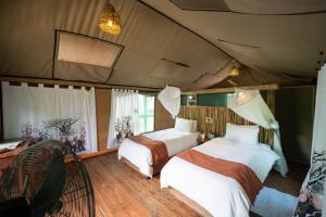 a bedroom with two beds in a tent at Nata Lodge in Nata