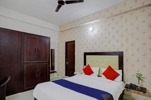 a bedroom with a bed with red and blue pillows at Shree Hotel in Lucknow