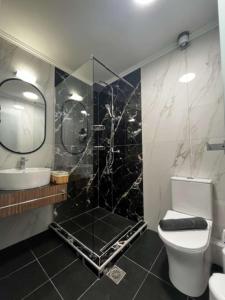 ein Bad mit einer Dusche, einem WC und einem Waschbecken in der Unterkunft My House Apartments in Pyrgadikia