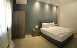 1 dormitorio con 1 cama y armario de madera en My House Apartments, en Pyrgadikia