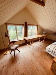 um quarto com uma mesa de madeira num sótão em Skogslund, Skåne em Veberöd