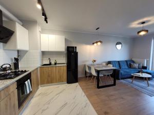 a kitchen and living room with a couch and a table at Fresh Apartment Great Location in Białystok