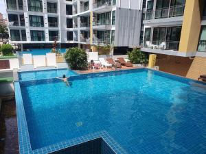 a person swimming in a large swimming pool in a building at Neo2 condo B 204 in Jomtien Beach