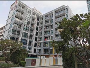 a large white apartment building with trees in front of it at Neo2 condo B 204 in Jomtien Beach
